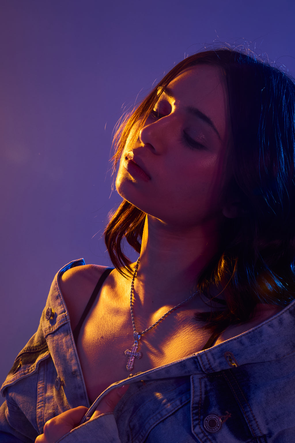 Woman wearing a denim jacket with a purple and blue gradient background